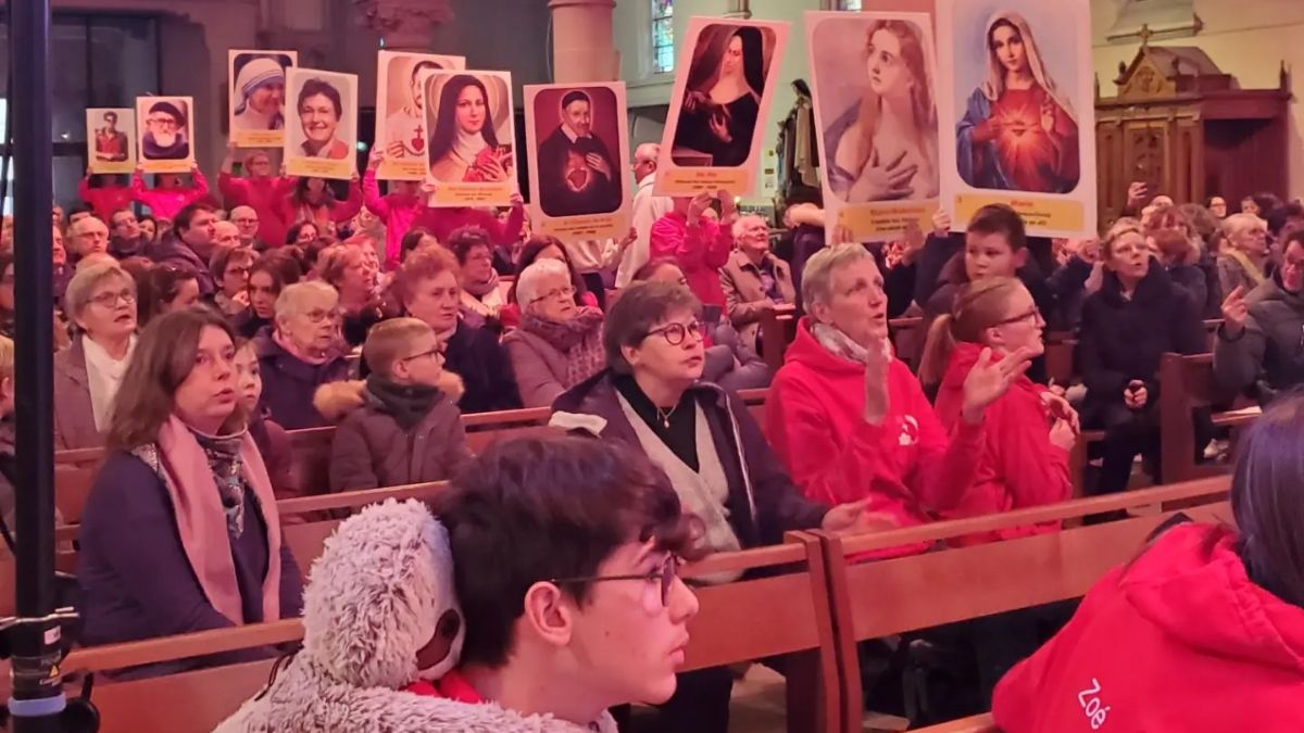 Les jeunes de l'aûmonerie apportant les portraits de témoins de la foi